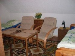 Gemütliches Wohn/Schlaf mit Bett, Tisch und zwei Stühlen.